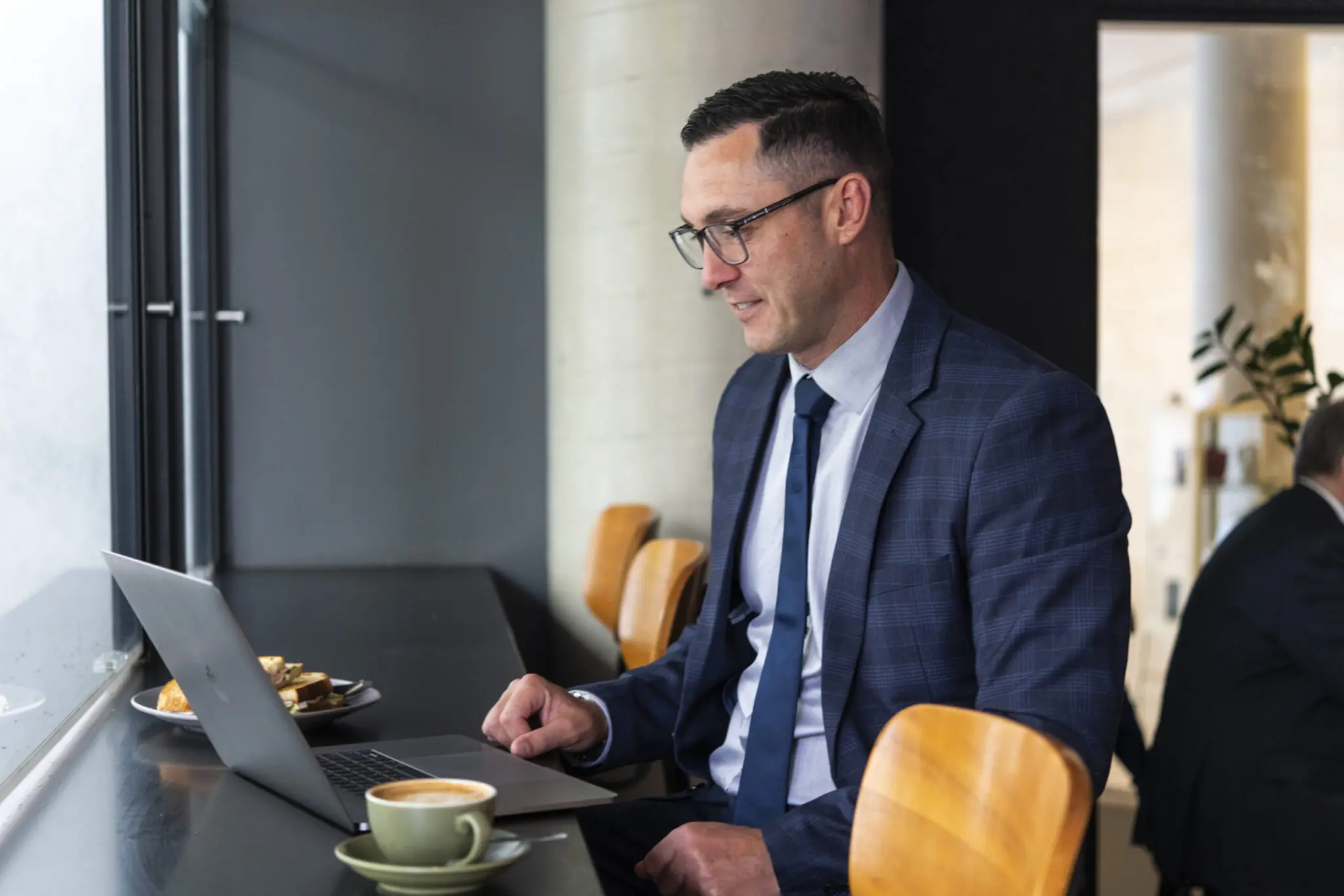 Agent 99 property agent Nick Nagel enjoying a coffee while doing work on his laptop